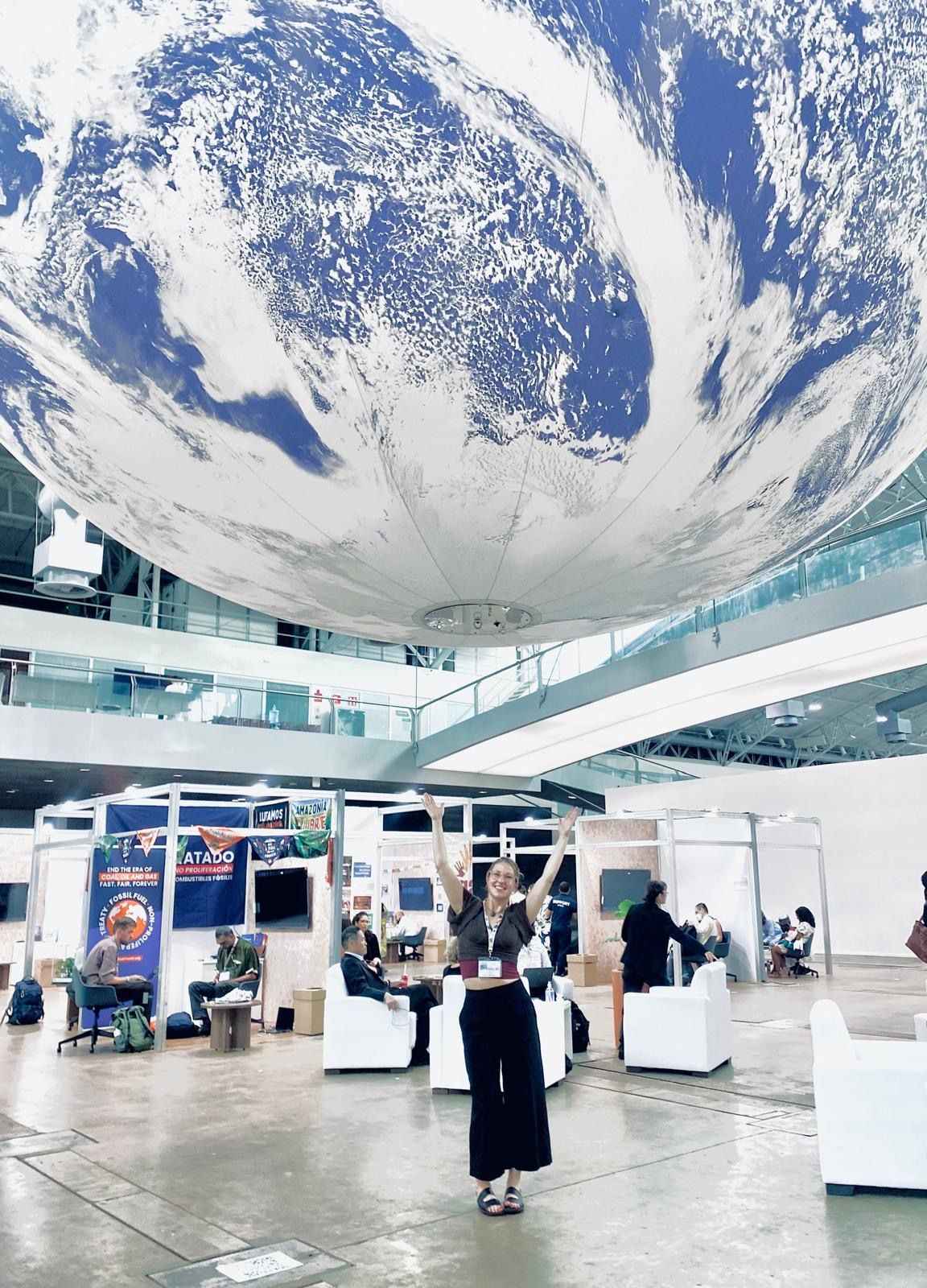 Person standing below globe in conference centre