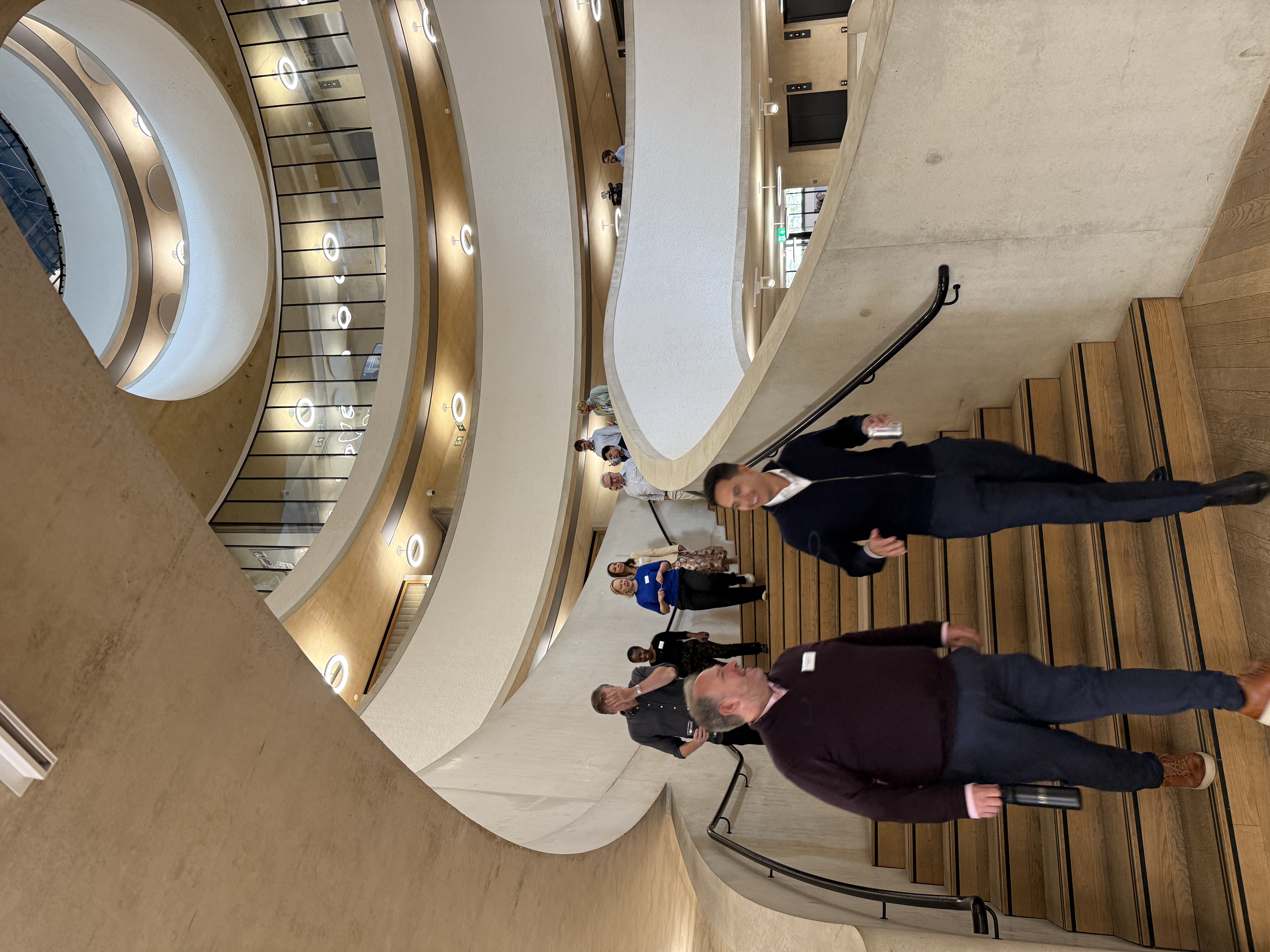 People descend spiral staircase smiling